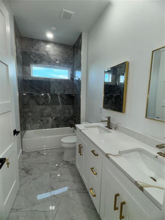 1721 McClellan Road Frostproof, FL 33843 - Photo 27 of 41 a bathroom with a granite countertop sink mirror bathtub and toilet