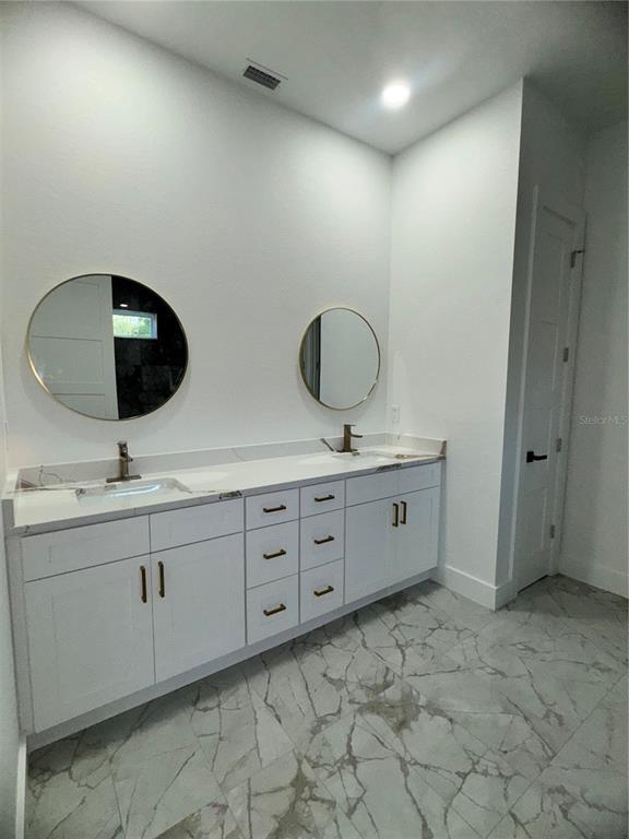 1721 McClellan Road Frostproof, FL 33843 - Photo 32 of 41 a bathroom with double sink and a mirror