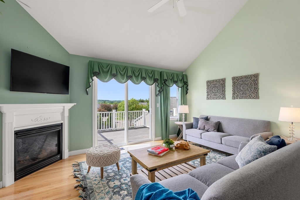 5 Strawberry Lane, Unit E Hudson, MA 01749 - Photo 15 of 42 a living room with furniture a flat screen tv and a fireplace