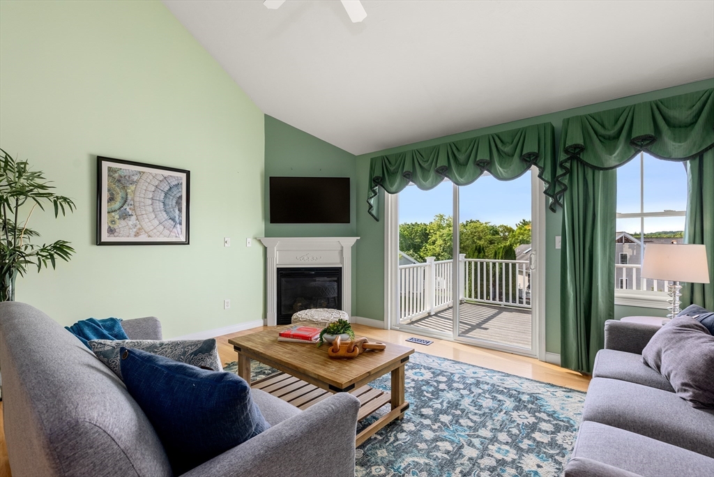 5 Strawberry Lane, Unit E Hudson, MA 01749 - Photo 16 of 42 a living room with furniture a flat screen tv and a fireplace
