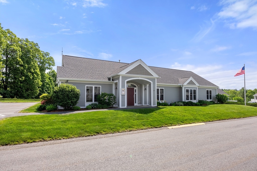 5 Strawberry Lane, Unit E Hudson, MA 01749 - Photo 38 of 42 a front view of a house with a yard and garage