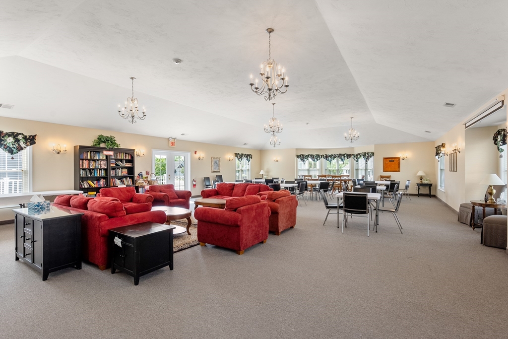 5 Strawberry Lane, Unit E Hudson, MA 01749 - Photo 39 of 42 a living room with furniture a chandelier and a window