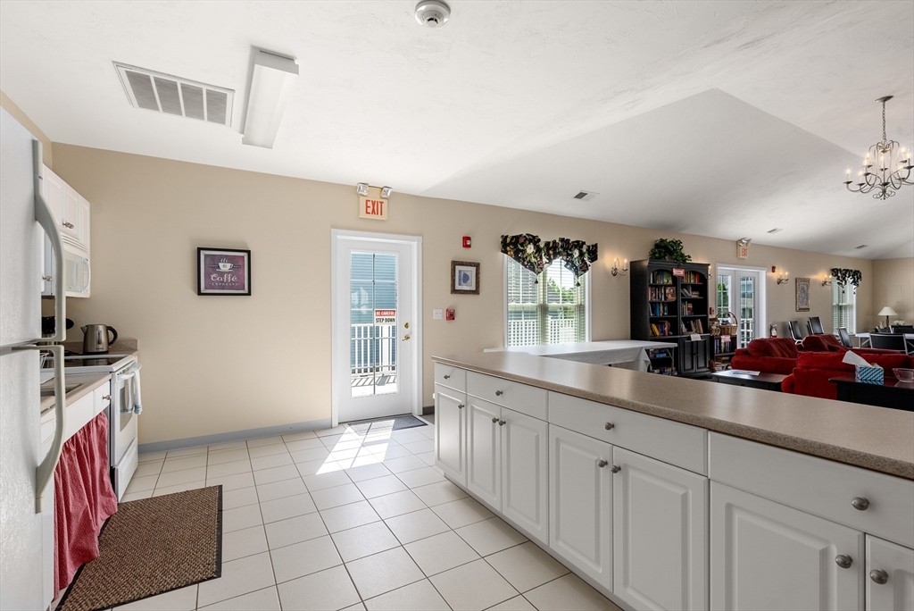 5 Strawberry Lane, Unit E Hudson, MA 01749 - Photo 40 of 42 a large kitchen with a sink and cabinets