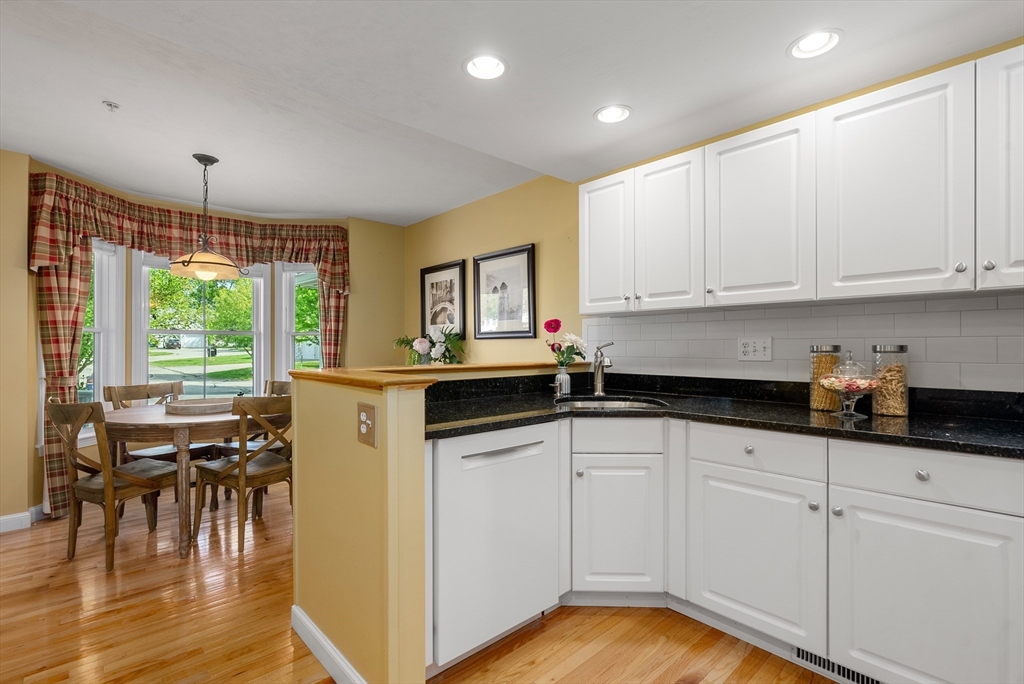 5 Strawberry Lane, Unit E Hudson, MA 01749 - Photo 5 of 42 a kitchen with granite countertop a stove a sink a dining table and chairs