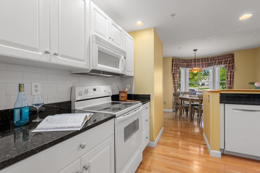 5 Strawberry Lane, Unit E Hudson, MA 01749 - Photo 6 of 42 a kitchen with stainless steel appliances granite countertop a stove a sink and a microwave