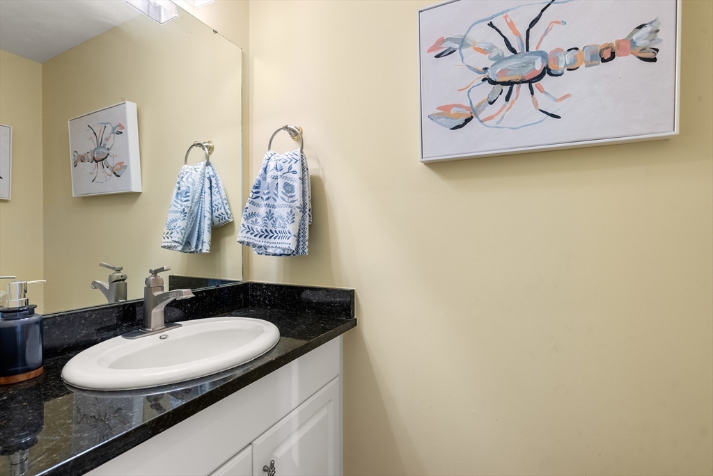 5 Strawberry Lane, Unit E Hudson, MA 01749 - Photo 10 of 42 a bathroom with a granite countertop sink and a mirror