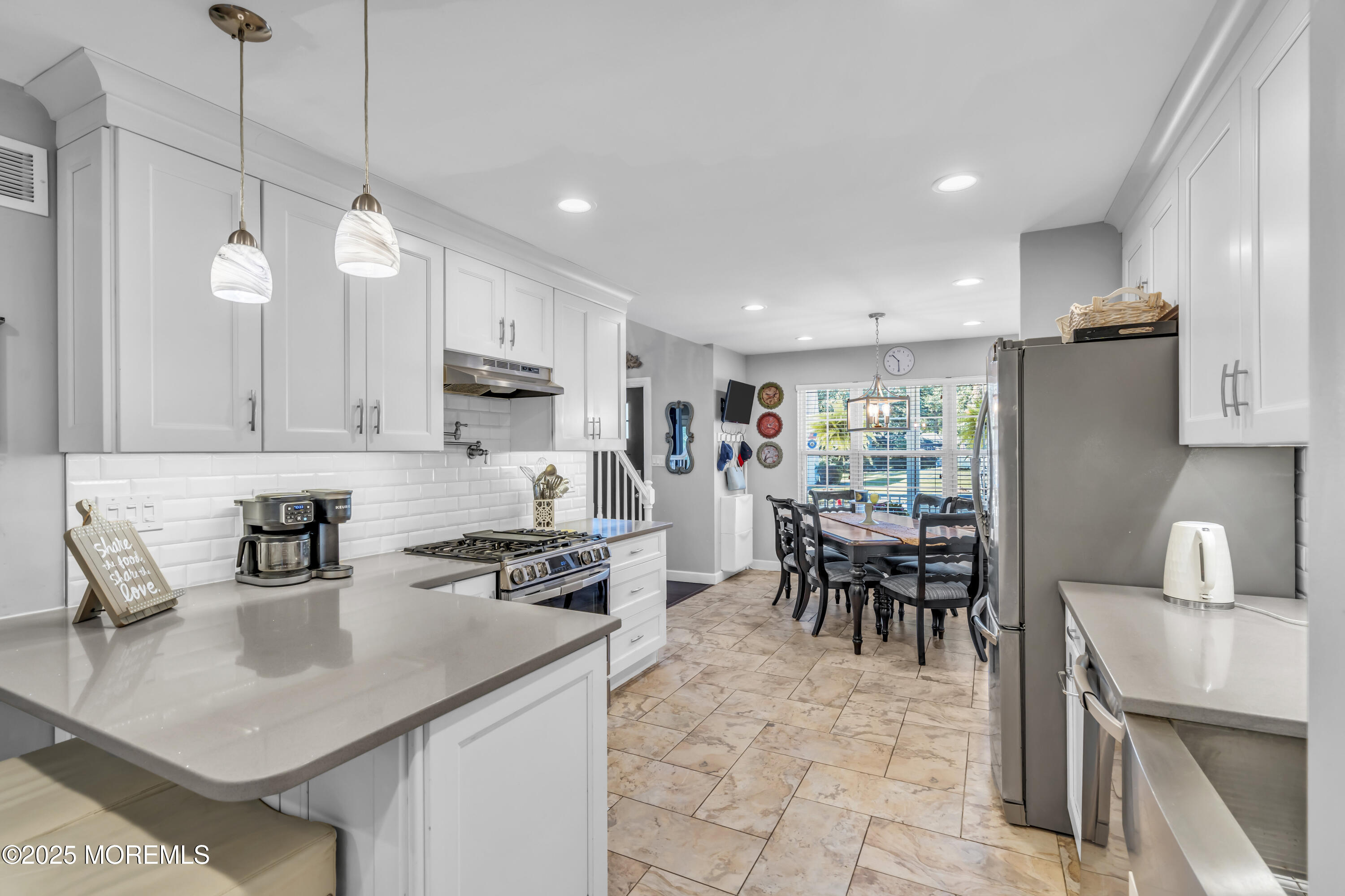 1 Sun Hollow Road Howell, NJ 07731 - Photo 10 of 47 a kitchen with stainless steel appliances granite countertop a stove top oven a sink a dining table and chairs with white cabinets
