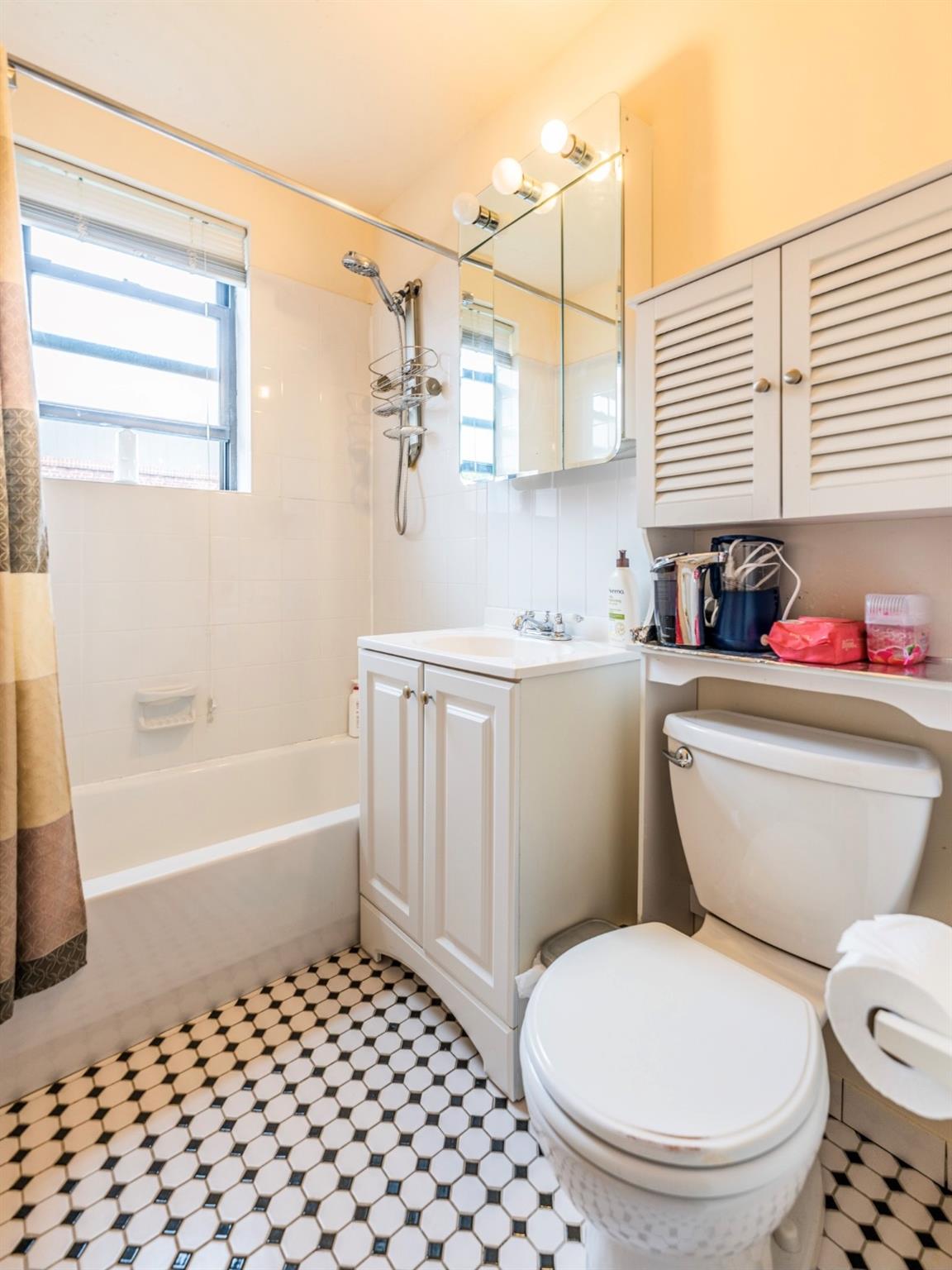 215-43 48th Avenue, Unit 3A Queens, NY 11364 - Photo 13 of 16 a bathroom with a sink a toilet and bathtub