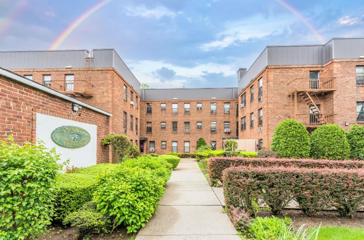 215-43 48th Avenue, Unit 3A Queens, NY 11364 - Photo 2 of 16 a front view of a building with a garden