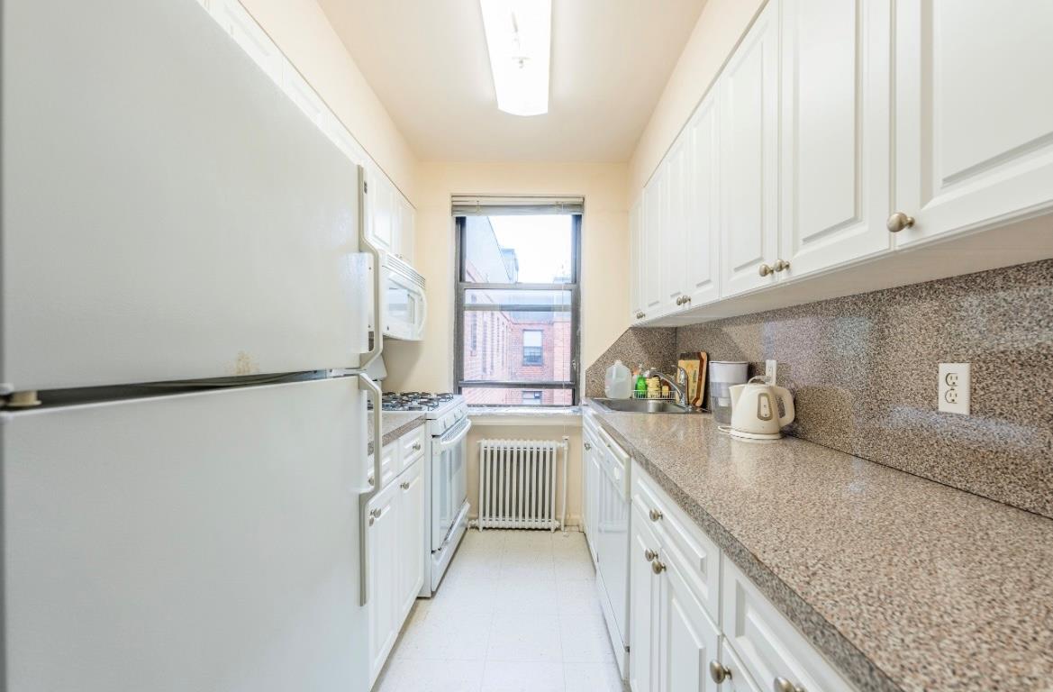 215-43 48th Avenue, Unit 3A Queens, NY 11364 - Photo 7 of 16 a kitchen with stainless steel appliances granite countertop a sink and a refrigerator