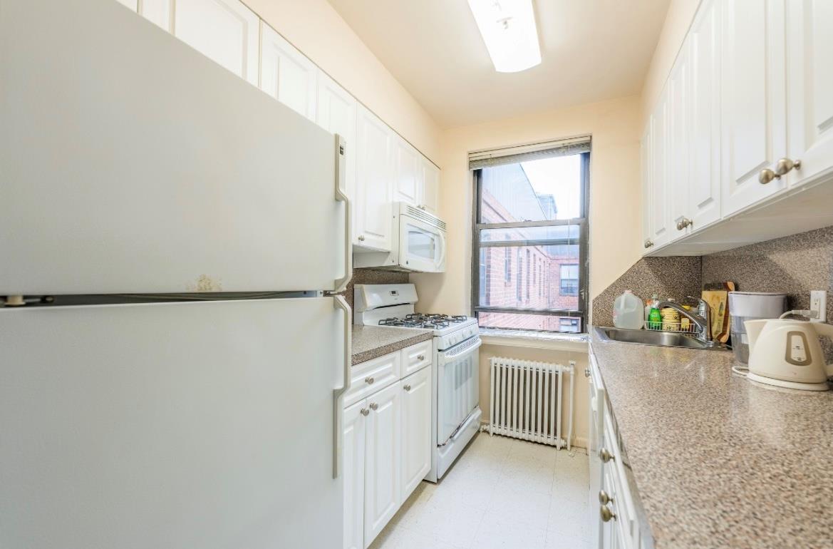 215-43 48th Avenue, Unit 3A Queens, NY 11364 - Photo 8 of 16 a kitchen with stainless steel appliances granite countertop a sink stove and refrigerator
