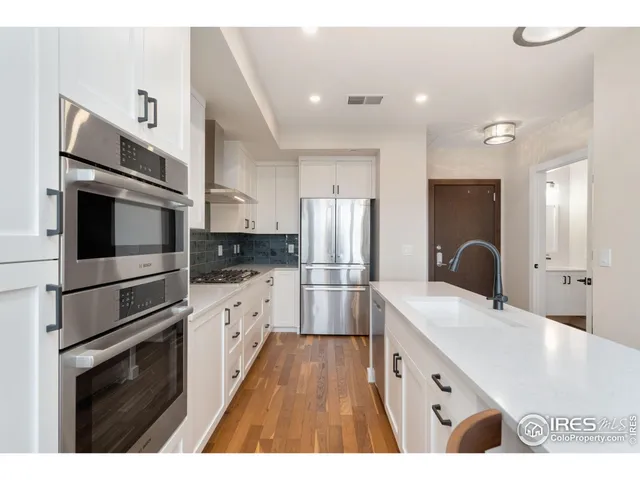 a kitchen with stainless steel appliances kitchen island granite countertop a refrigerator and a stove top oven