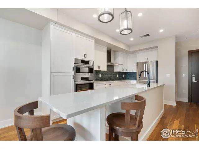 a kitchen with stainless steel appliances granite countertop a sink a stove and a refrigerator