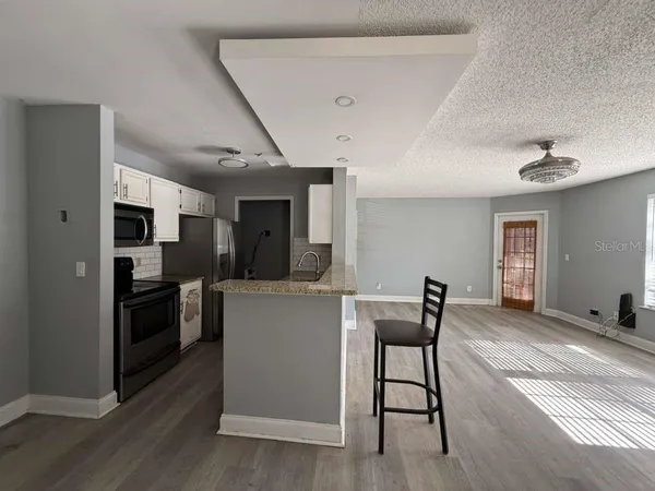 a kitchen with stainless steel appliances kitchen island granite countertop a refrigerator and a stove top oven