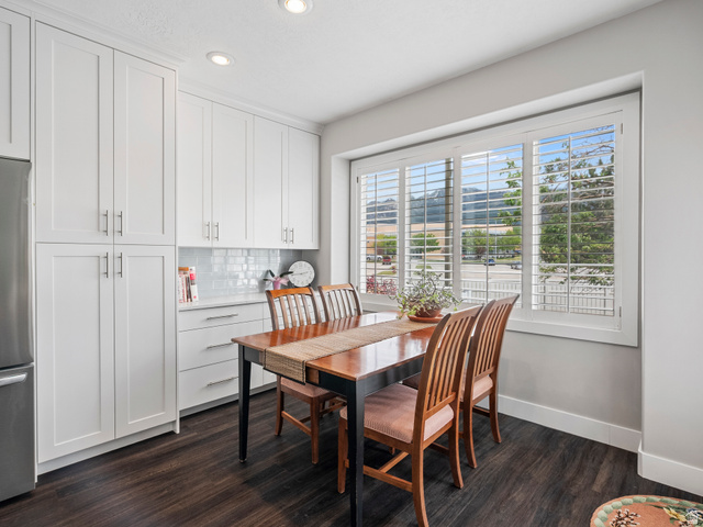 11881 Cottage View Lane Draper, UT 84020 - Photo 6 of 29 Dining area featuring white shaker-style cabinetry, a white subway tile backsplash, and a large window with white plantation shutters