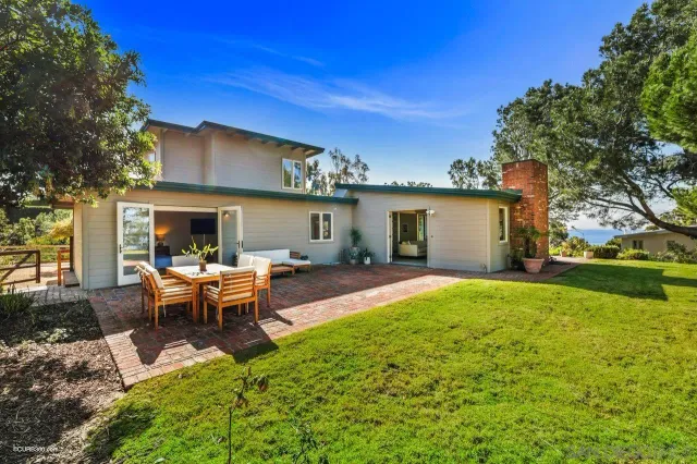 a view of a house with backyard and sitting area