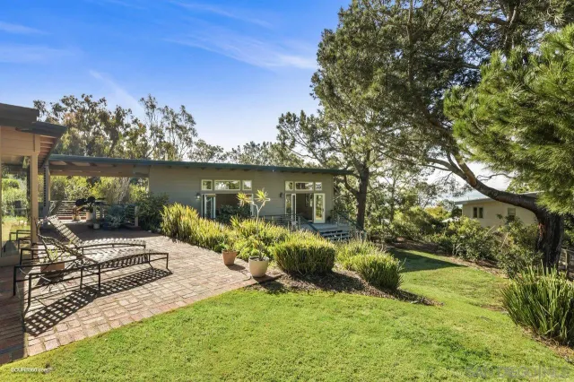 a view of a lake with a yard and potted plants