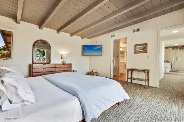 a spacious bedroom with a bed and a dresser