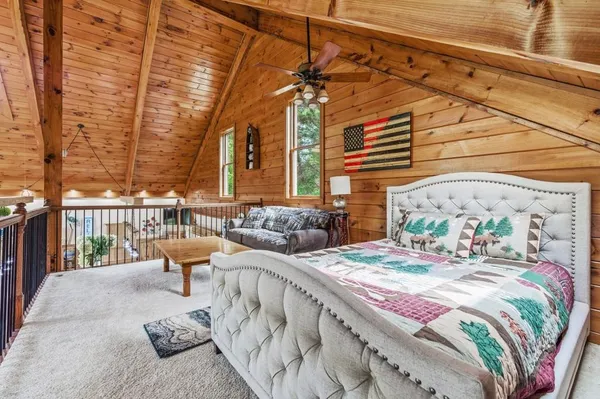 a bedroom with a large bed and a flat tv screen