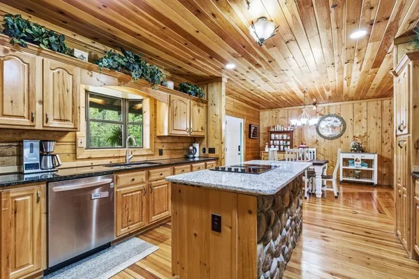 a kitchen with stainless steel appliances granite countertop a stove and a wooden floor