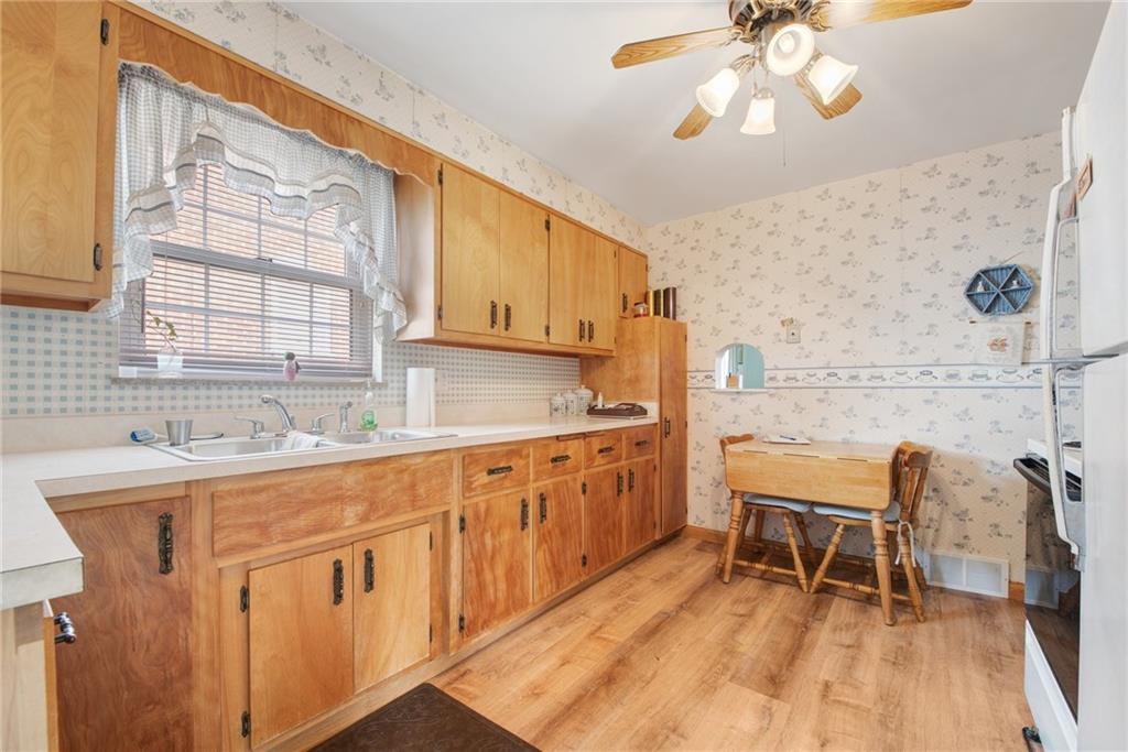 208 Eastern Drive Lower Burrell, PA 15068 - Photo 5 of 25 a kitchen with a sink chairs and cabinets
