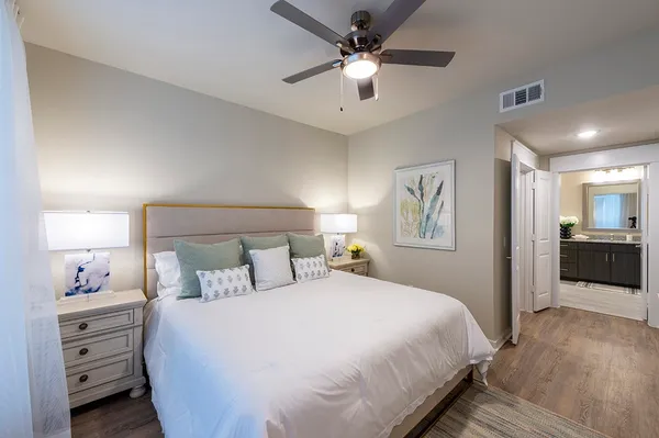 a bedroom with a large bed and a chandelier