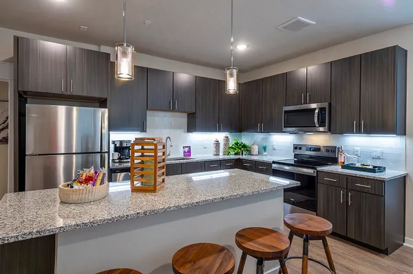 a kitchen with granite countertop a sink stainless steel appliances and cabinets