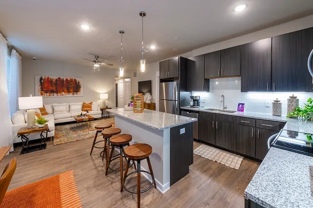 a kitchen with a table chairs refrigerator and microwave