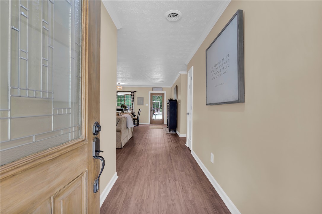 3030 Smith McGee Road Iva, SC 29655 - Photo 6 of 46 A welcoming entry hall featuring durable wood-look flooring and a view into the bright living spaces beyond.