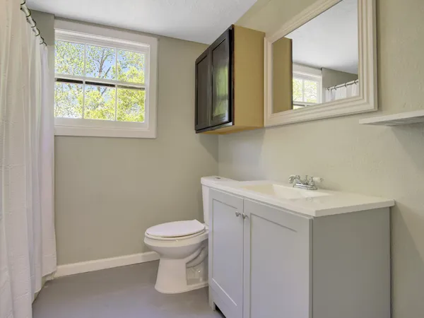 a bathroom with a toilet sink and mirror