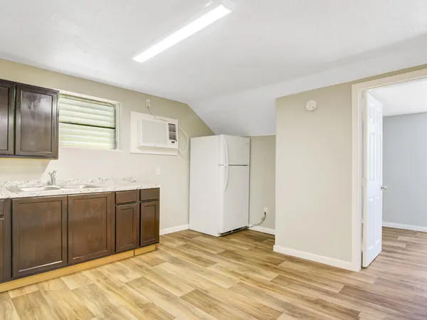 a view of kitchen with granite countertop cabinets and wooden floor