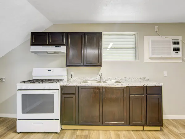 a kitchen with granite countertop a stove and a sink