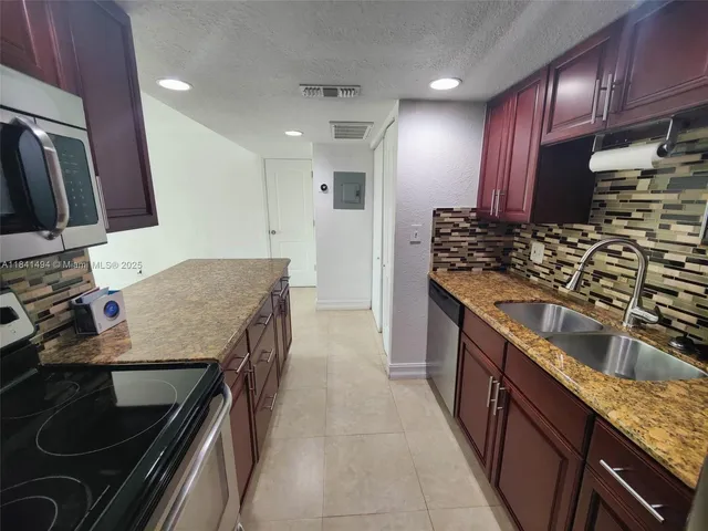 a kitchen with stainless steel appliances granite countertop a sink stove and refrigerator