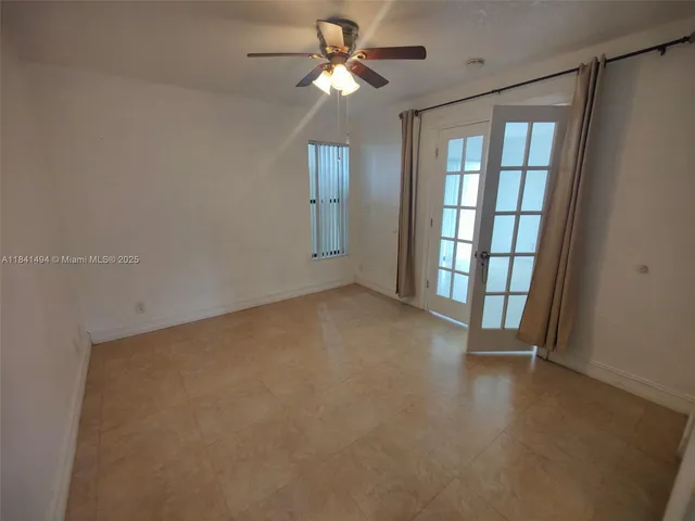 an empty room with a window and wooden floor