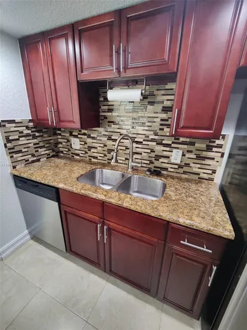 a kitchen with granite countertop wooden cabinets and stainless steel appliances