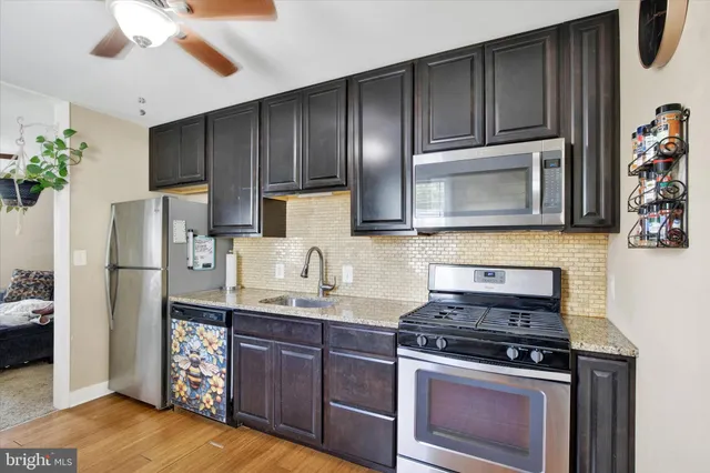 a kitchen with stainless steel appliances granite countertop a stove a refrigerator and a microwave