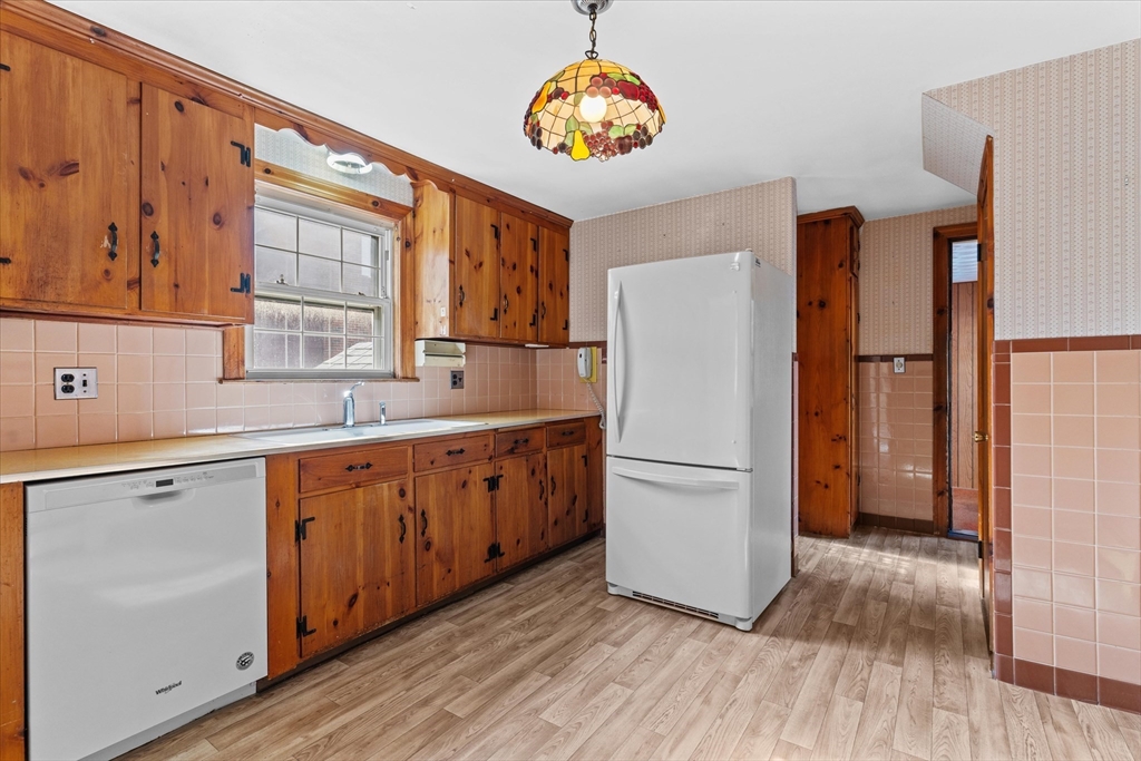 9 Pershing Road Salem, MA 01970 - Photo 12 of 42 a kitchen with stainless steel appliances granite countertop a refrigerator sink and wooden cabinets