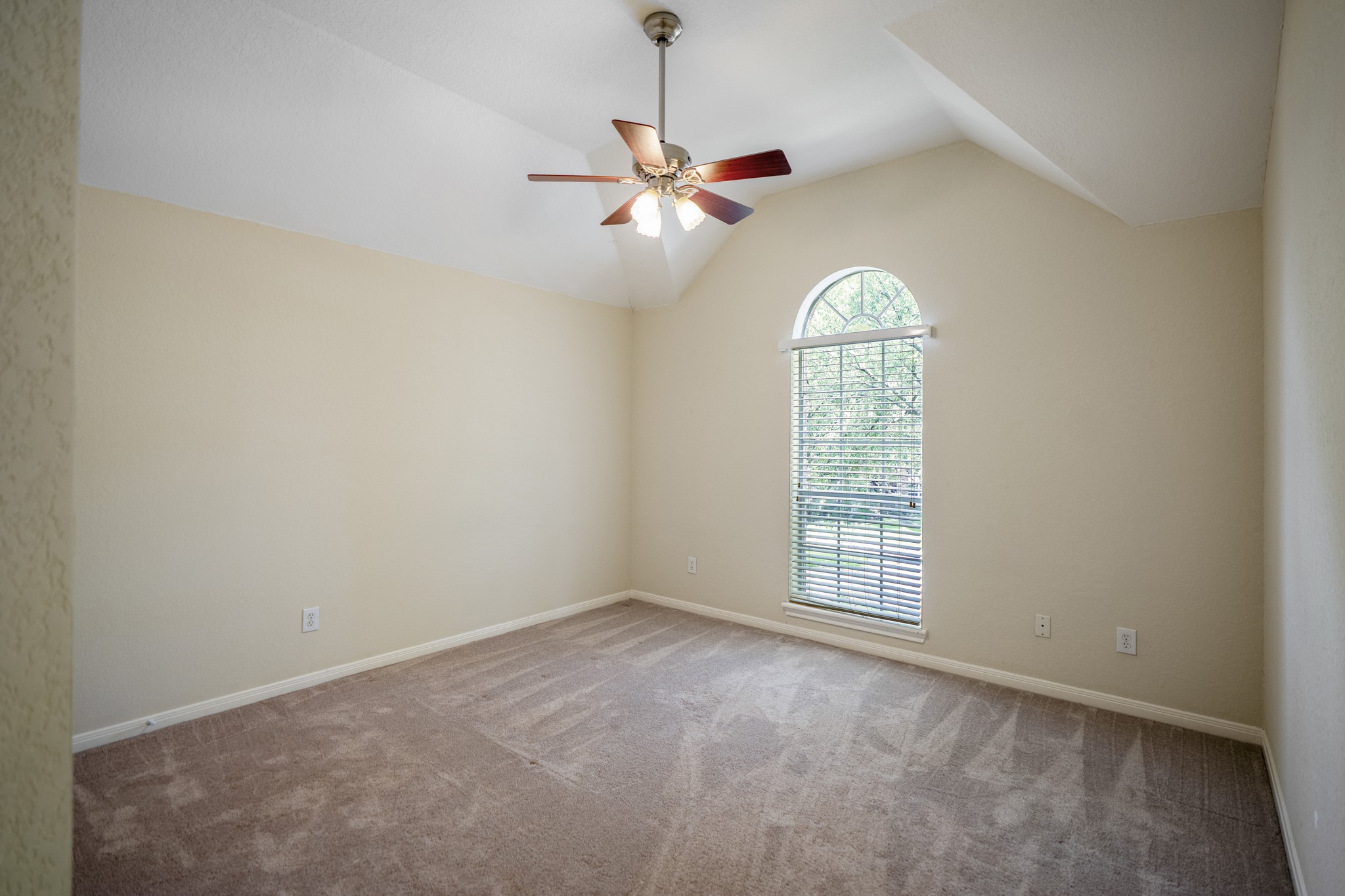 5807 Sequoia Trace Court Spring, TX 77379 - Photo 26 of 50 This third bedroom pairs a vaulted ceiling with an arched window, adding character and natural light while keeping the second-floor layout flexible and functional.