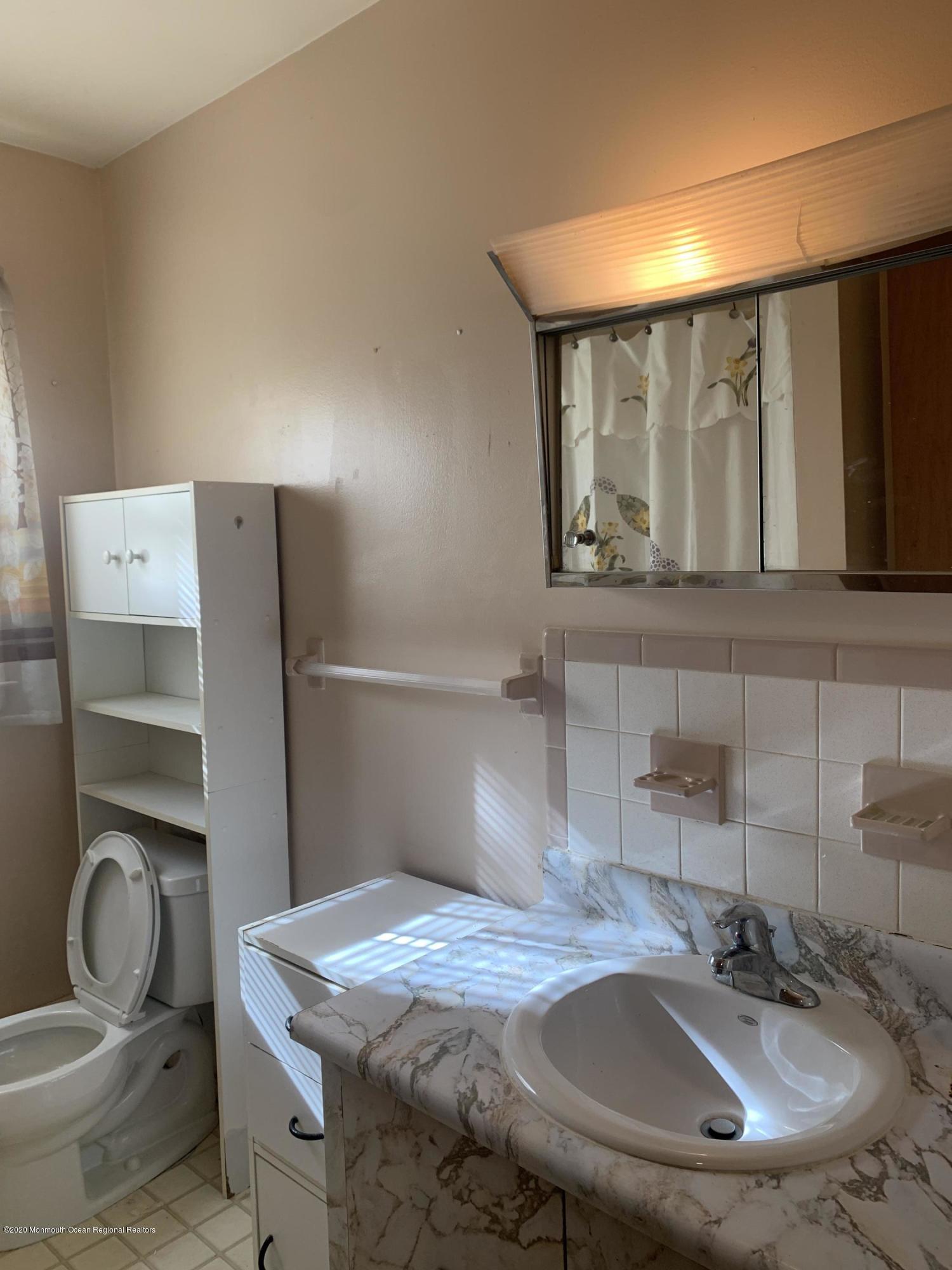 129 Georgetown Road Toms River, NJ 08757 - Photo 12 of 15 a bathroom with a granite countertop sink a toilet and mirror