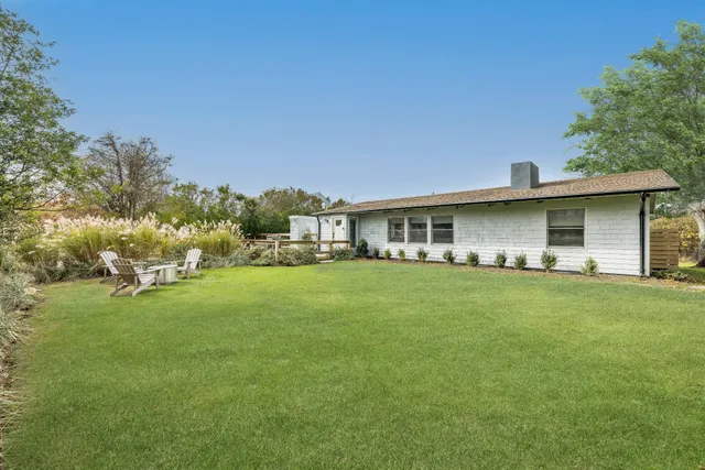 a front view of house with outdoor seating and green space