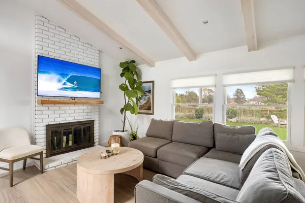 a living room with furniture a fireplace and a large window