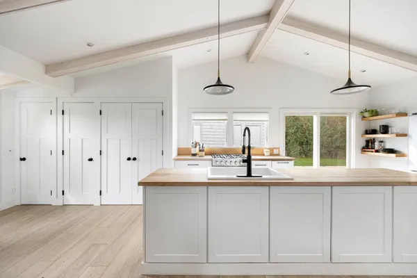a kitchen with granite countertop a sink and white cabinets