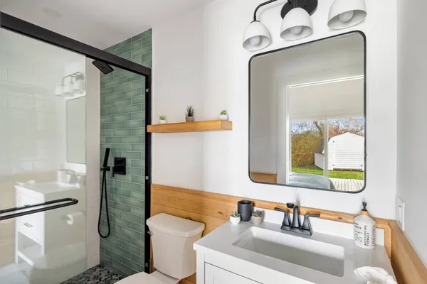 a bathroom with a sink vanity mirror and toilet