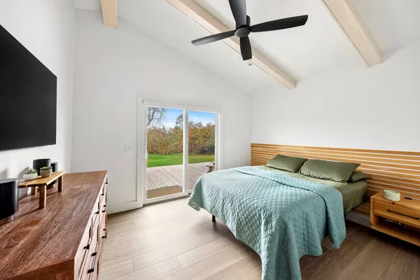 a bedroom with a bed window and a flat screen tv