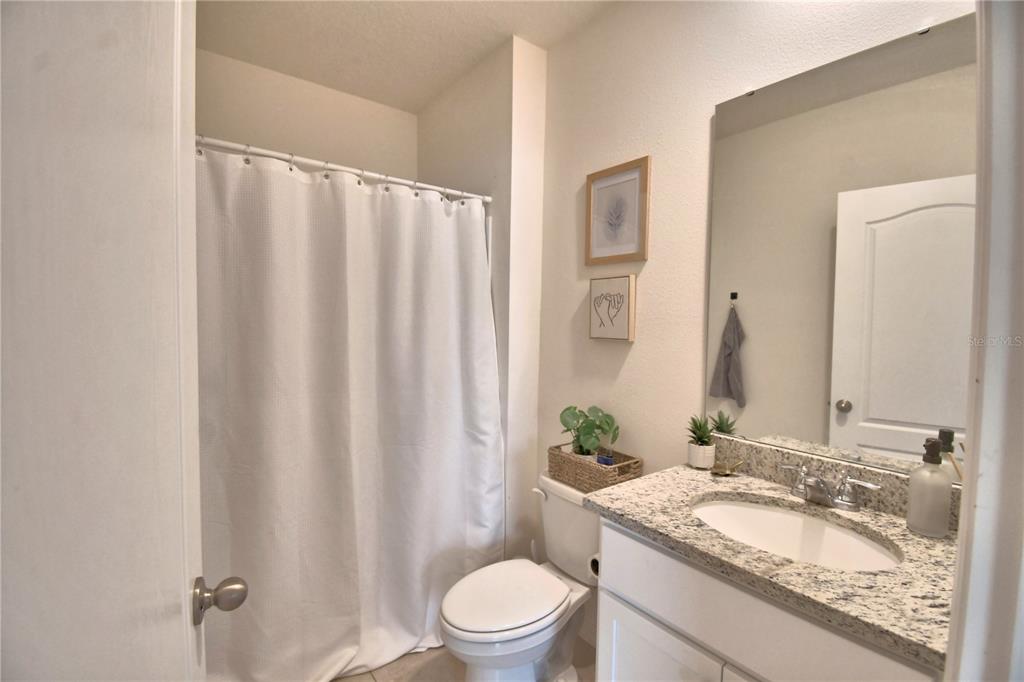 2839 Moulin Road Davenport, FL 33837 - Photo 21 of 75 a bathroom with a granite countertop sink toilet and a mirror