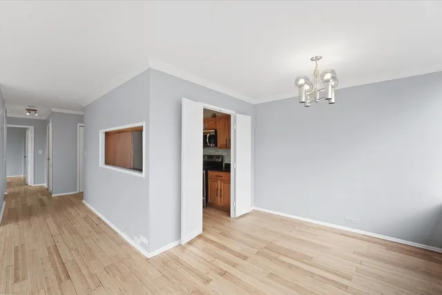 a view of a livingroom with wooden floor and chandelier