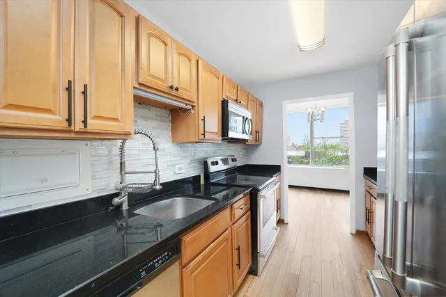 a kitchen with granite countertop a sink a stove and cabinets