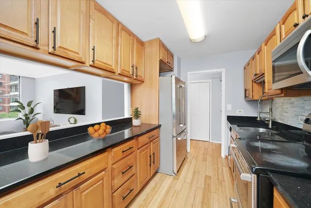 a kitchen with stainless steel appliances a sink a stove and a wooden floor