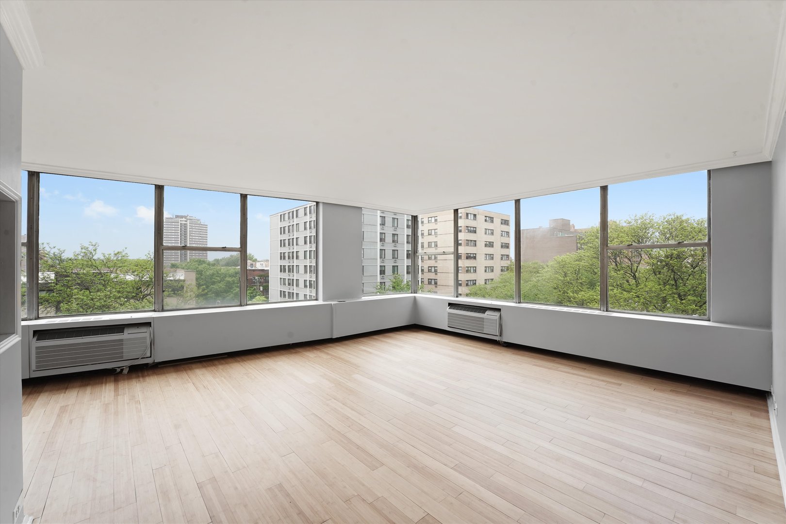 5757 North Sheridan Road, Unit 5J Chicago, IL 60660 - Photo 8 of 44 an empty room with wooden floor and windows