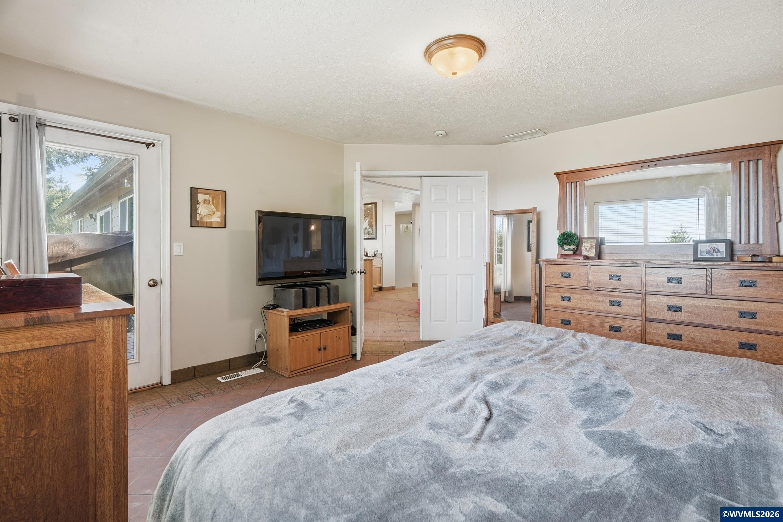 1110 Reuben Boise Road Dallas, OR 97338 - Photo 22 of 49 a bedroom with a bed and a flat screen tv